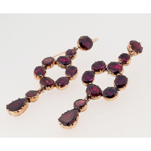 393A - A pair of antique garnet set gold pendant earrings of circle and drop form, 5cm long,