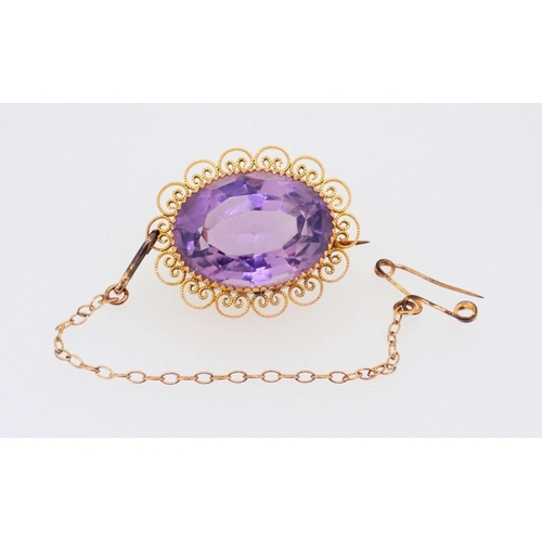 394 - A 9 carat gold oval filigree mounted amethyst brooch, 2.5cm, boxed