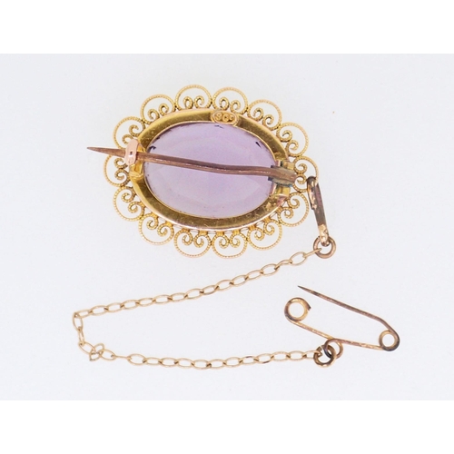 394 - A 9 carat gold oval filigree mounted amethyst brooch, 2.5cm, boxed