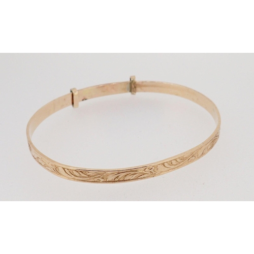 439 - A 9 carat gold christening bangle on metal core