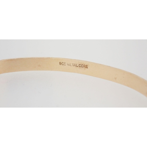 439 - A 9 carat gold christening bangle on metal core