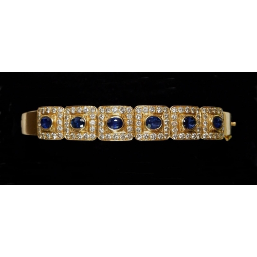 441 - An 18 carat gold hinged bangle with six square panels set sapphires within diamond surround, total w... 