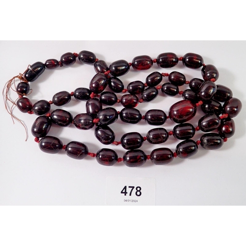 478 - A long cherry amber bead necklace, 105cm long