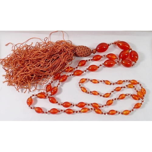 499 - A 1920's long orange bead necklace with silk tassel