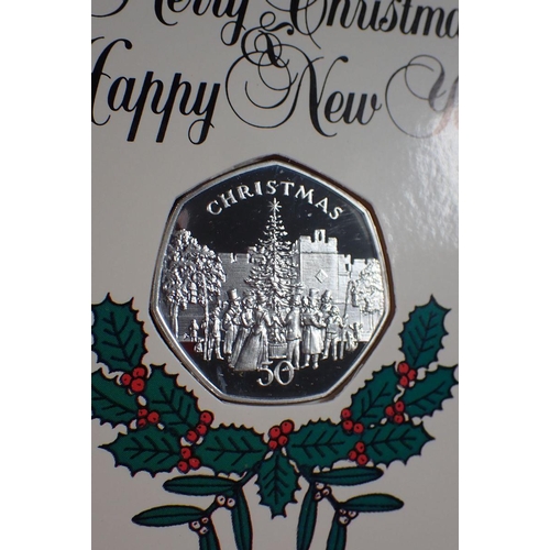 687 - Three Pobjoy Mint Isle of Man silver proof Christmas fifty pences, each mounted in Christmas card, 1... 