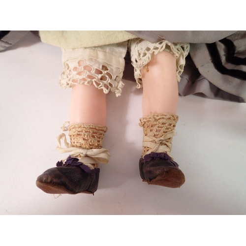 825 - A Victorian wax doll with cloth body, wax arms and legs, original clothing, hat, shoes bolster pillo... 