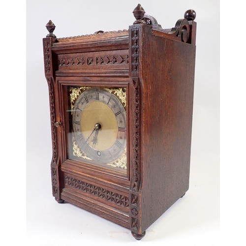 944 - A Victorian oak mantel clock with carved case and brass dial