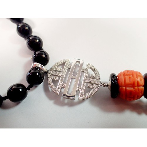 444 - An Art Deco style 15ct white gold onyx and coral bead necklace with diamond set geometric drop  and ... 