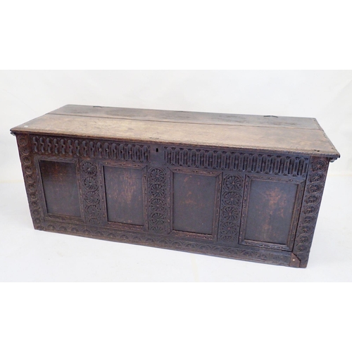 1015 - A large 18th century oak coffer with four panel carved front, lacking supports, 149cm wide