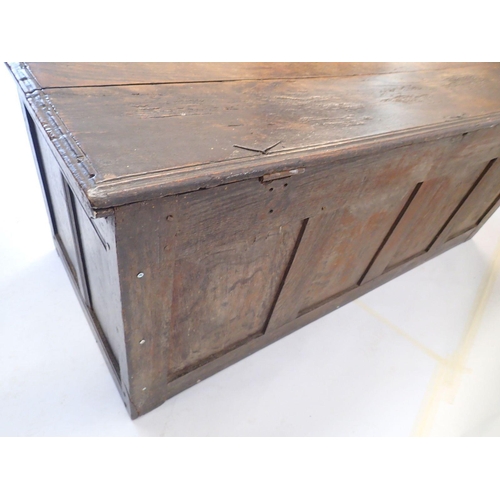 1015 - A large 18th century oak coffer with four panel carved front, lacking supports, 149cm wide