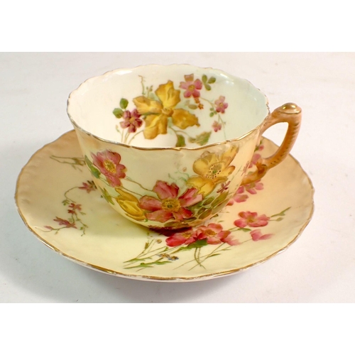 131 - A Royal Worcester cup and saucer painted spray of flowers on ivory blush ground, restored