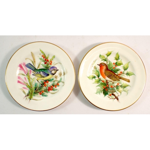 134 - A pair of Royal Worcester miniature pin dishes painted blue tit and robin, 10.5cm diameter