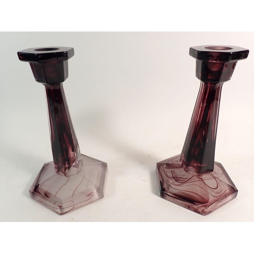 168 - A purple cloud glass bowl on stand and pair of candlesticks, 11cm tall