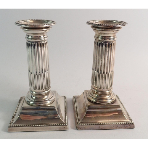 191 - A pair of silver column form candlesticks, 13.54cm tall, Sheffield 1904 by Martin, Hall & Co