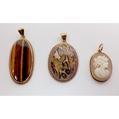 283 - A 14 carat gold tigers eye pendant, a 9 carat gold stone pendant and a gold framed cameo - unmarked