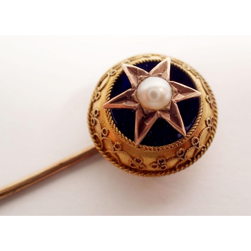 304 - A Victorian yellow metal stick pin with blue enamel and pearl star, cased