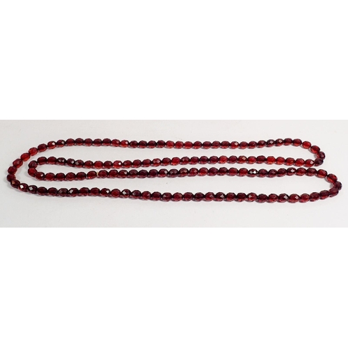 353 - A long single strand faceted cherry amber style bead necklace, approx 150cm