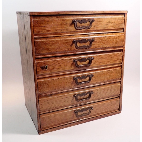 391 - A collectors oak cabinet of six drawers including various watch faces, watch and clock accessories a... 