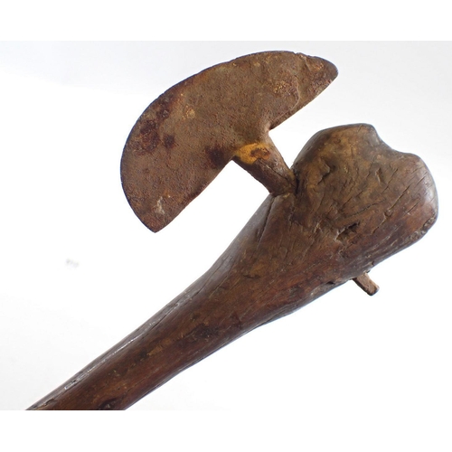 512 - An antique tribal fighting axe with wooden handle and metal head, 67cm