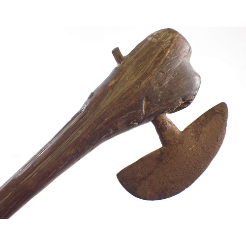 512 - An antique tribal fighting axe with wooden handle and metal head, 67cm