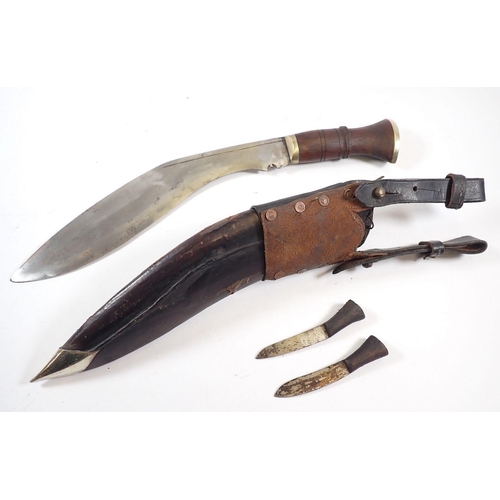 517 - A 20th century Gurkha Kukri knife with wooden grip in leather sheath with Frog and Karda and Chakmak... 