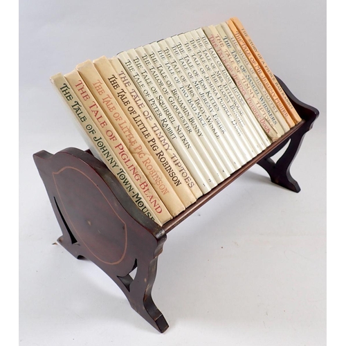 589 - A set of Beatrix Potter books in Edwardian mahogany bookstand, 28cm wide