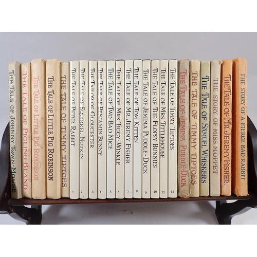 589 - A set of Beatrix Potter books in Edwardian mahogany bookstand, 28cm wide