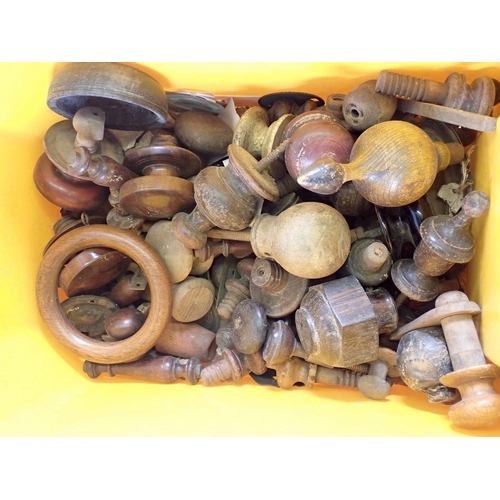 716 - A box of carved treen door knobs, finials etc.