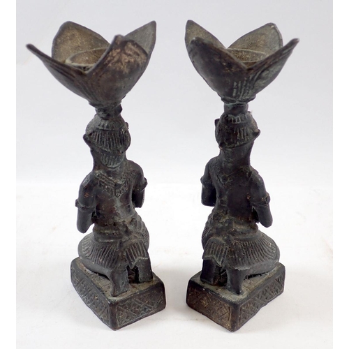 723 - A pair of Egyptian brass candlesticks in the form of kneeling praying women, 15.5cm