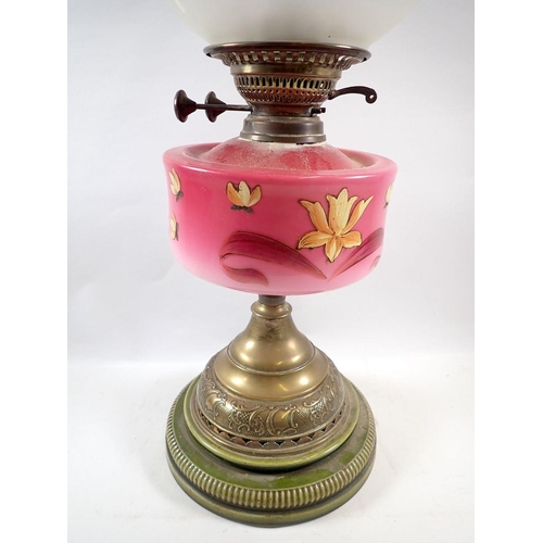 752 - A Victorian oil lamp with pink floral painted glass reservoir, stoneware and brass base and etched g... 