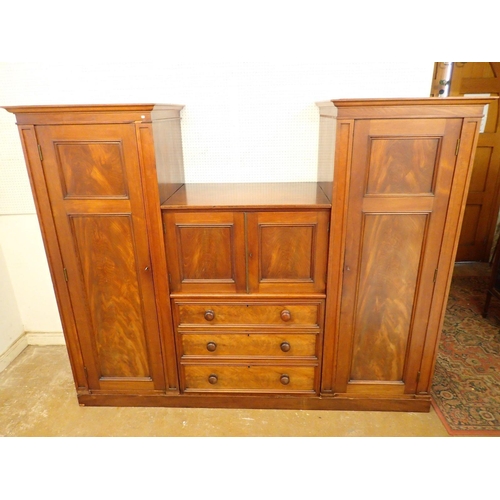 819 - A Victorian mahogany wardrobe and linen press with two hanging compartments flanking three drawers a... 