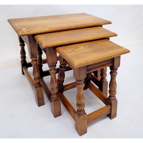 961 - A nest of three oak occasional tables on turned supports