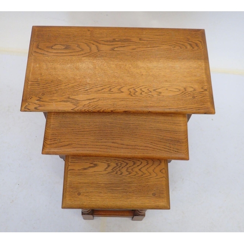 961 - A nest of three oak occasional tables on turned supports