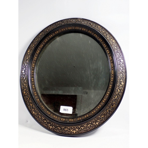 965 - An oval ebonised and gilt framed mirror, 42 x 38cm