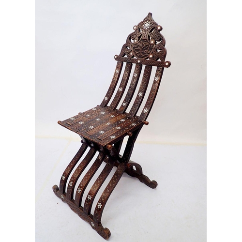 976 - An Islamic teak and mother of pearl folding chair with carved script