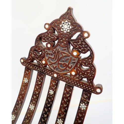 976 - An Islamic teak and mother of pearl folding chair with carved script