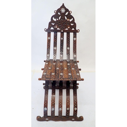 976 - An Islamic teak and mother of pearl folding chair with carved script