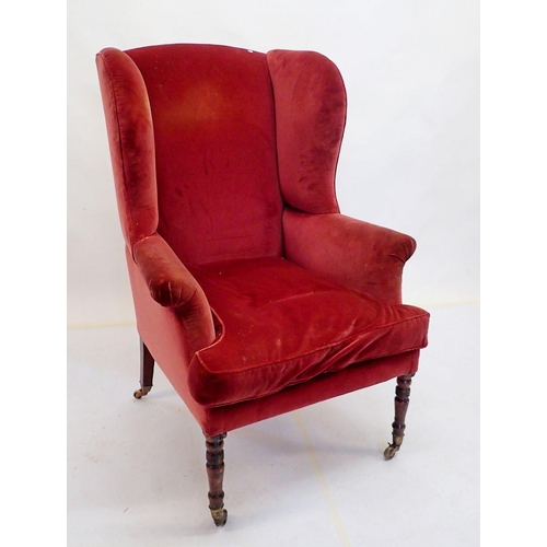 988 - A late Georgian wing armchair on slender turned supports