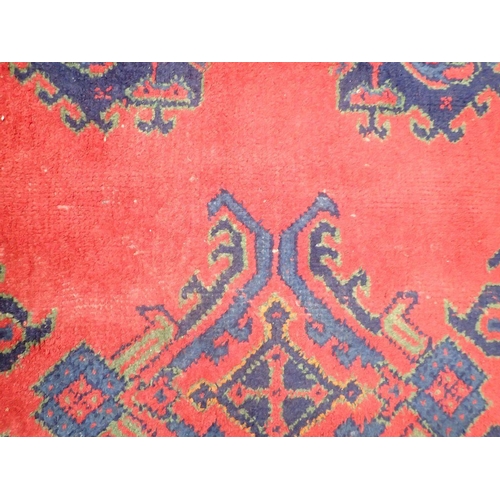 1016 - A large Turkish carpet with blue and green motifs on a red ground, 340 x 368cm