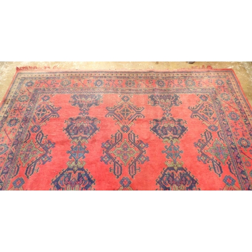 1016 - A large Turkish carpet with blue and green motifs on a red ground, 340 x 368cm