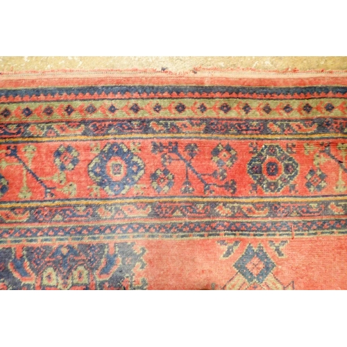 1016 - A large Turkish carpet with blue and green motifs on a red ground, 340 x 368cm