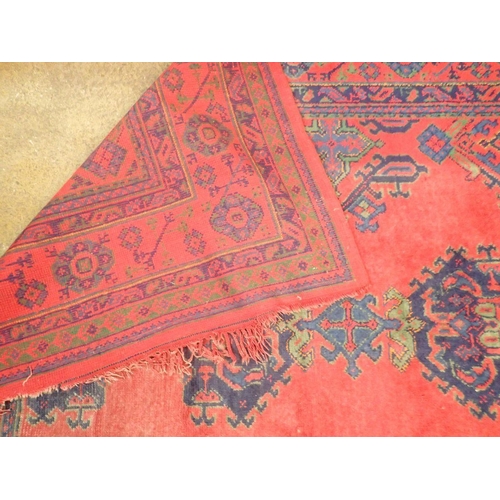 1016 - A large Turkish carpet with blue and green motifs on a red ground, 340 x 368cm