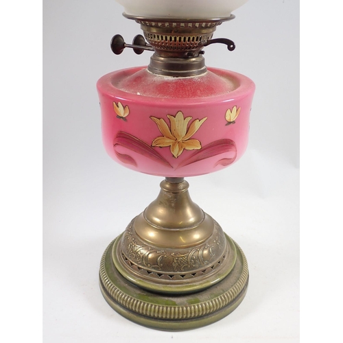 1065 - A Victorian oil lamp with pink floral painted glass reservoir, stoneware and brass base and etched g... 