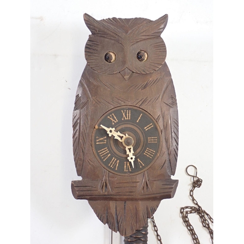 1294 - A Black Forrest owl form carved wood clock with moving eyes, 20cm tall