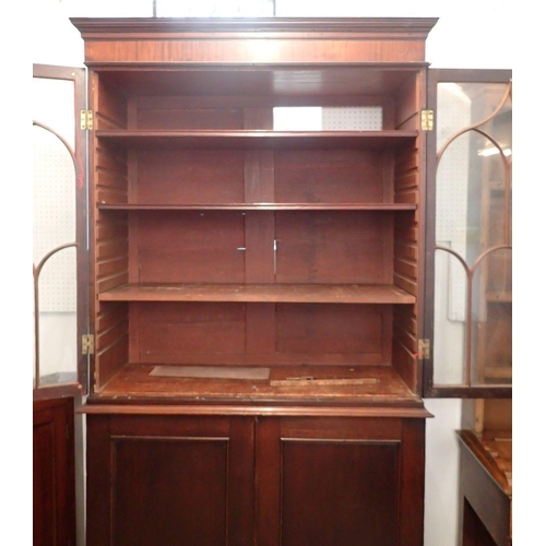 1327 - A Regency mahogany bookcase with two Gothic arch glazed doors over panelled cupboard, all on bracket... 