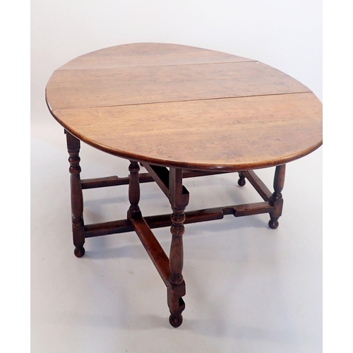 1332 - An 18th century oak drop-leaf dining table on turned supports, 123 x 175cm