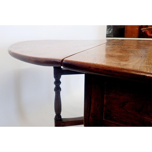 1332 - An 18th century oak drop-leaf dining table on turned supports, 123 x 175cm