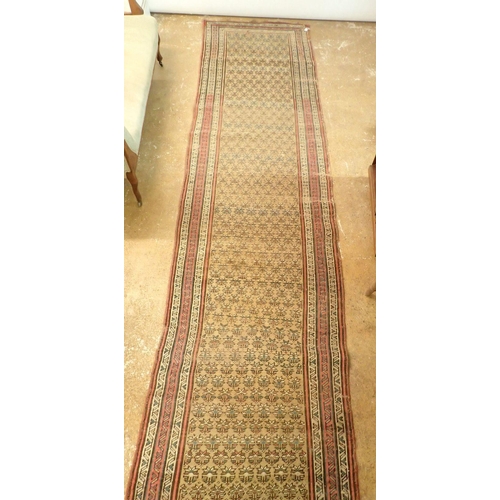 1341 - A Turkish runner with multiple guls on an ochre ground, 390 x 97cm