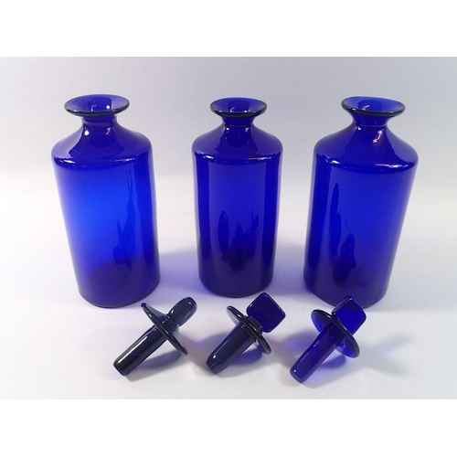 226 - Three Bristol blue pharmacy jars and covers, 23cm tall