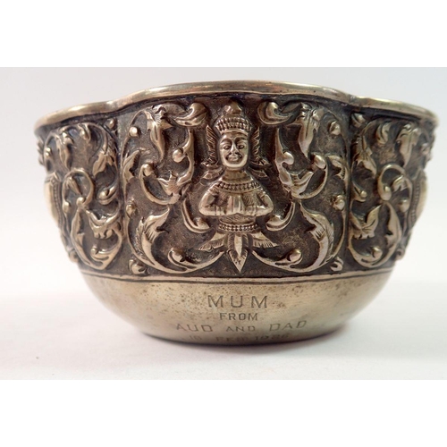 324 - A Burmese white metal bowl with embossed foliage and deity, inscribed and dated 1926, maks to base, ... 